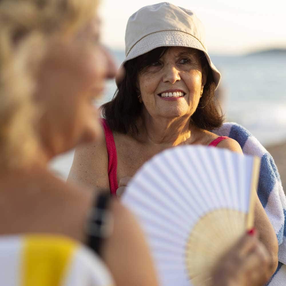 Une femme senior de 80 ans en vacances à la plage avec un bob sur la tête