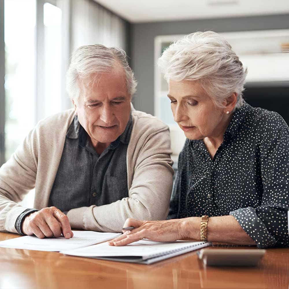 Deux aidants seniors consultent le dossier d'assurance vieillesse pour les aidants