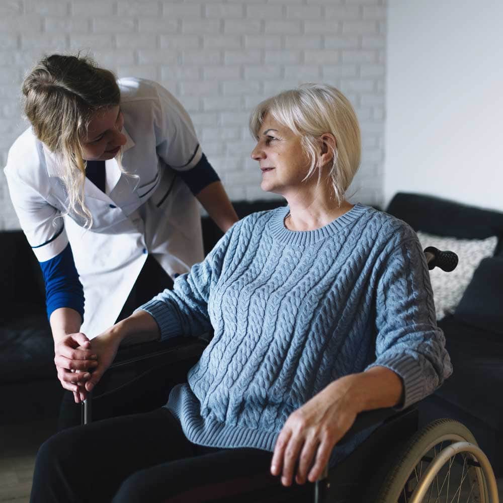 Une femme senior qui perçoit la MVA (majoration pour la vie autonome) accompagnée de son infirmière