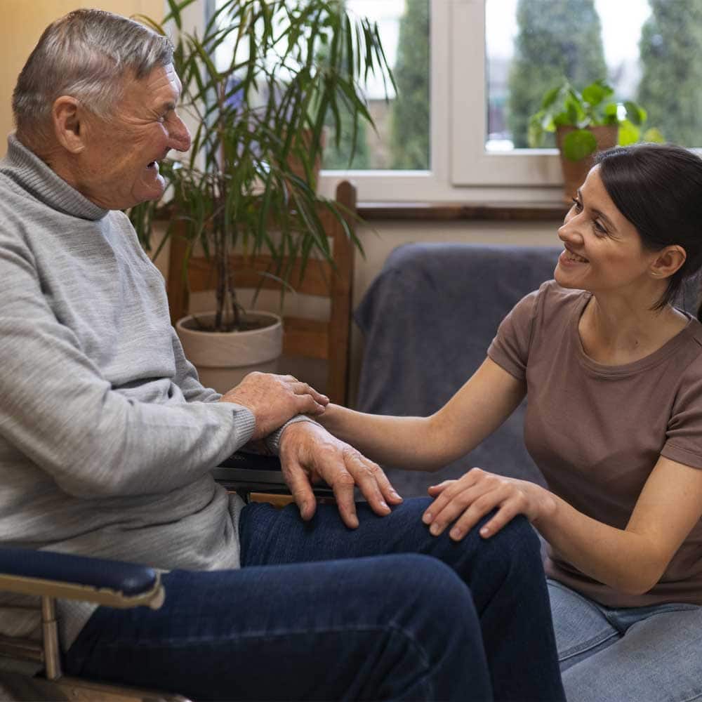 Un homme en situation de handicap, bénéficiant de la majoration pour tierce personne, avec son aide à domicile