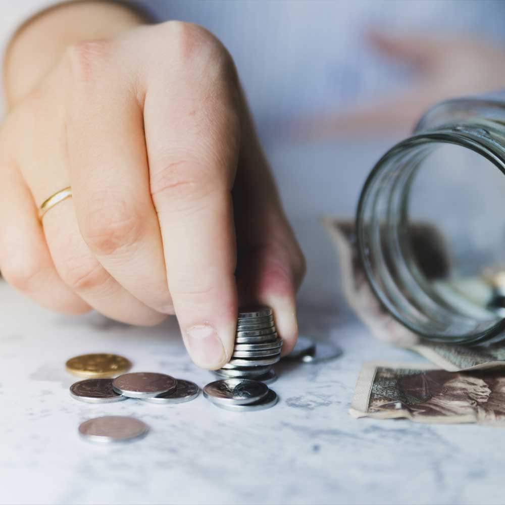 Une femme compte des pièces de monnaie en espérant pouvoir bénéficier des aides financières pour senior