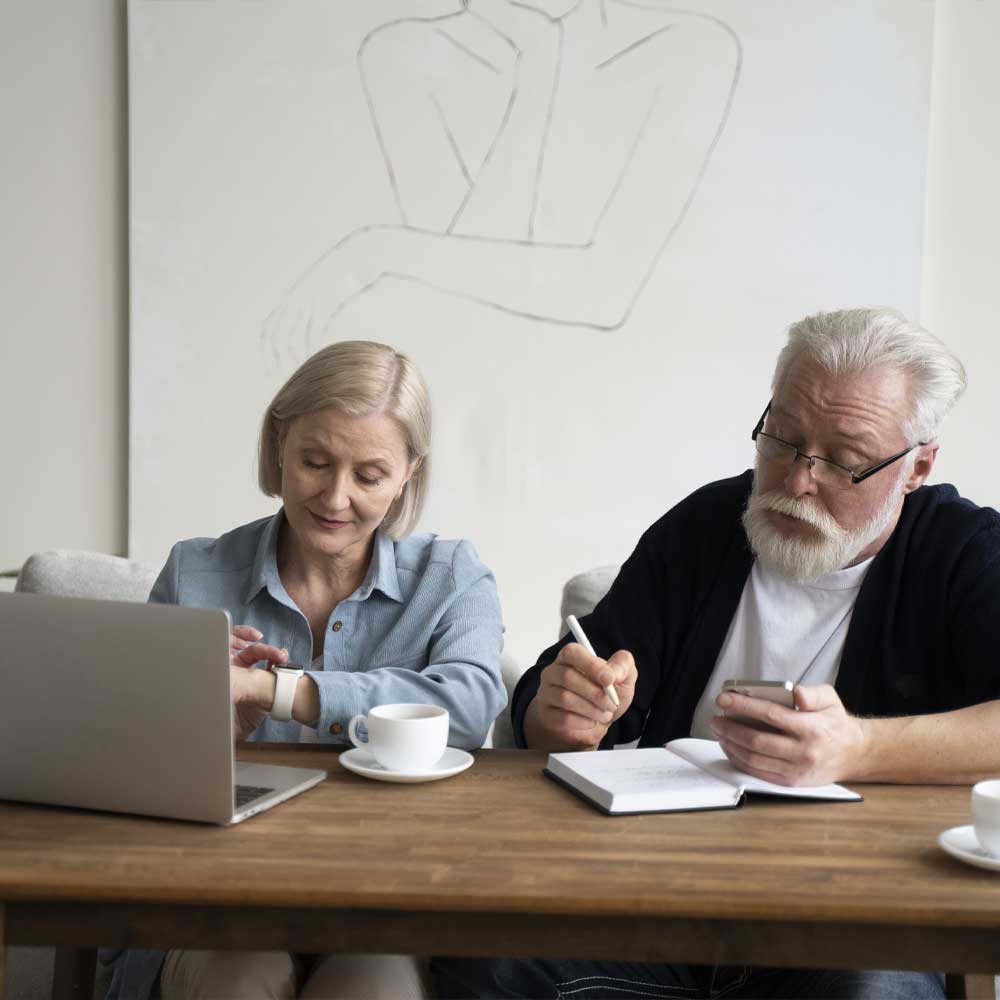 Un homme et une femme seniors sont en train de préparer la succession de leur proche en se demandant si l'APA est récupérable par le Conseil départemental